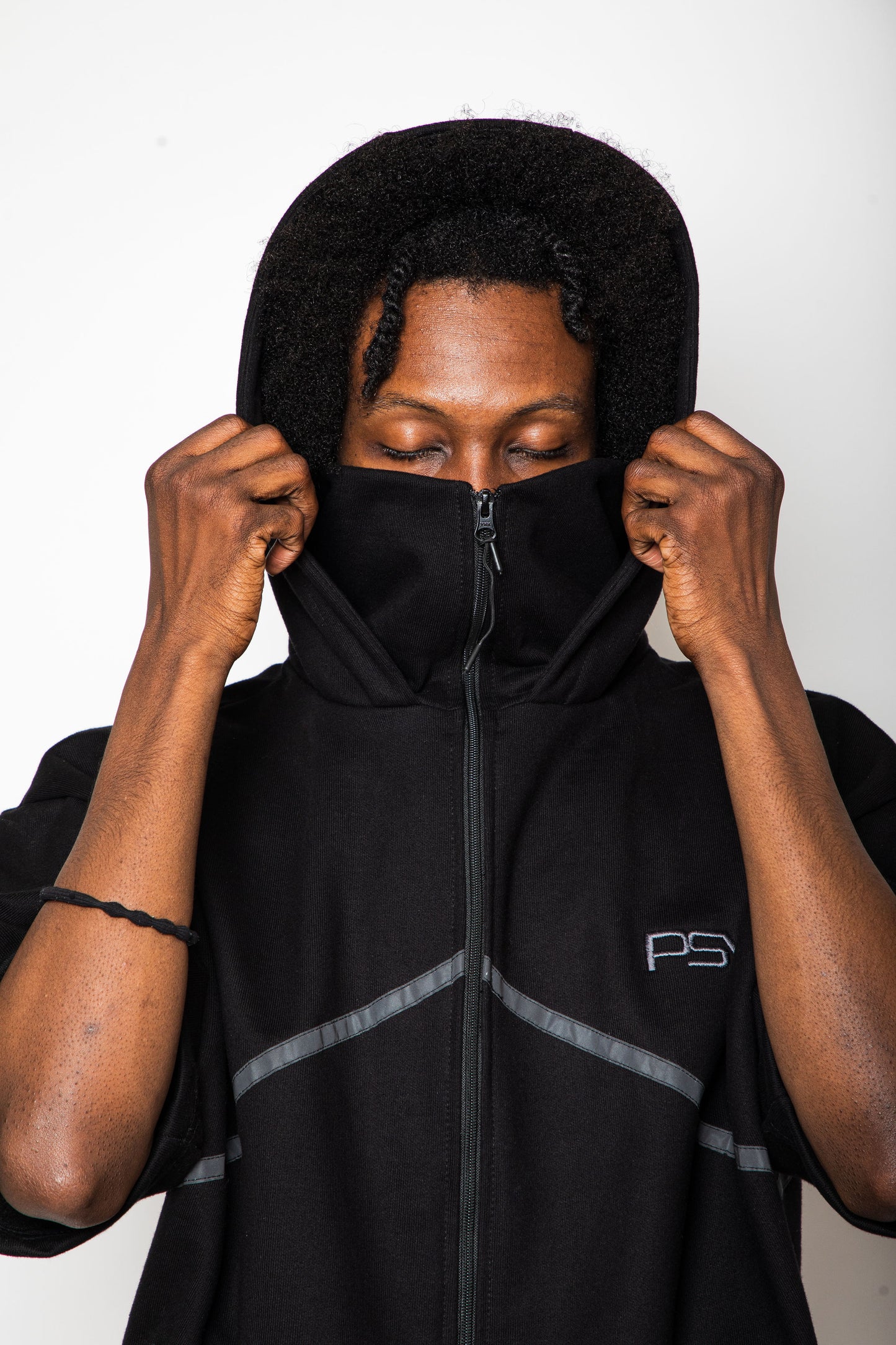 Person wearing a black hoodie with a logo on a white background